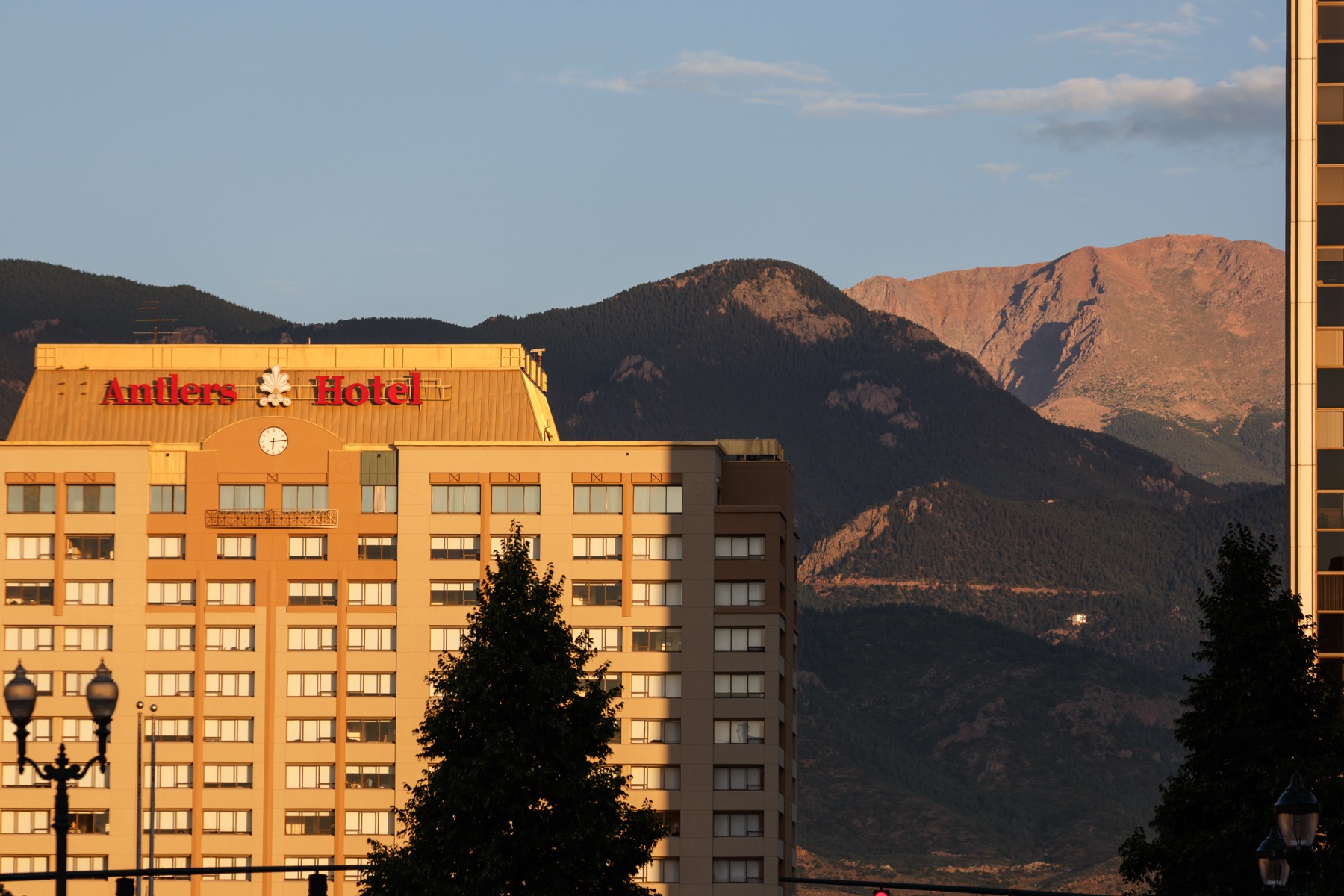 The Antlers hotel exterior at sunrise with Pikes Peak in the background